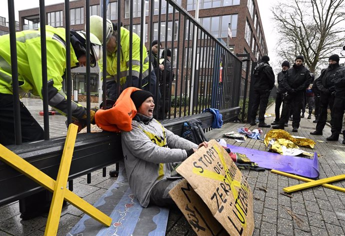 13 January 2023, North Rhine-Westphalia, Essen: Firefighters work to free environmental activists who chained themselves to the gate of the main headquarters of the energy provider RWE. The activists are protesting against the clearing of Lützerath in t