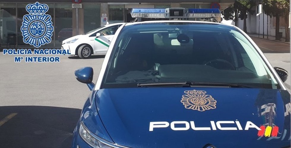 Vehículo de la Policía Nacional, junto a un taxi
