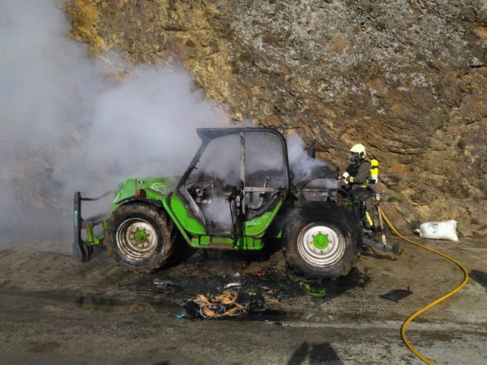 Un bombero apagando el fuego en el tractor
