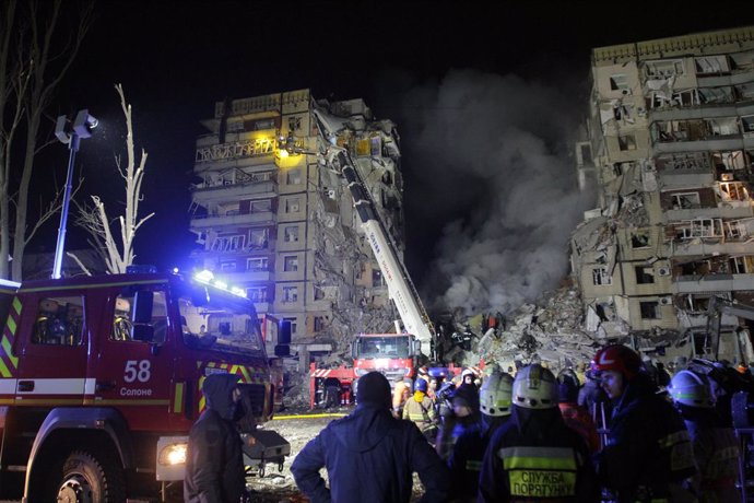 14 January 2023, Ukraine, Dnipro: Rescuers check for survivors on the standing section of a destroyed building after a Russian rocket attack on an apartment block in Dnipro. Photo: -/Ukrinform/dpa