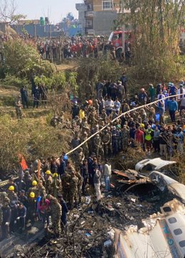 Membres de l'equip de rescat i persones en general es reuneixen entorn del lloc on es va estavellar un avió ATR72 de Yeti Airlines en el qual viatjaven 72 persones en Pokhara, en l'oest del Nepal.