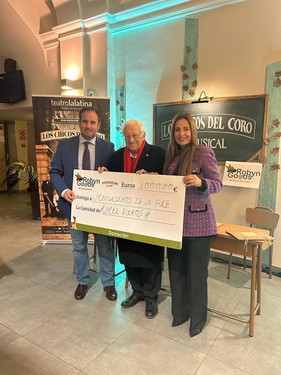 El padre Ángel, de Mensajeros de la Paz, recibe un cheque de 1.000 euros, recaudado en el merchandising de 'Los Chicos del Coro'
