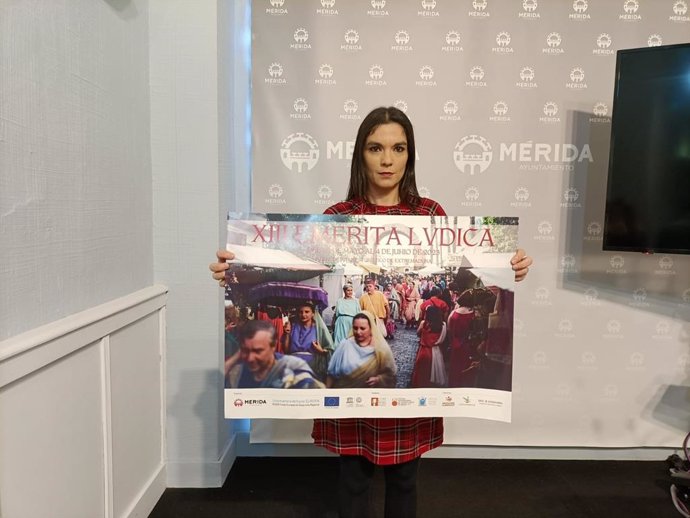 La delegada de Turismo, Pilar Amor, sostiene el cartel promocional de Emérita Lvdica que se exhibirá en la Feria de Turismo, Fitur, en Madrid, este lunes en el Ayuntamiento de Mérida