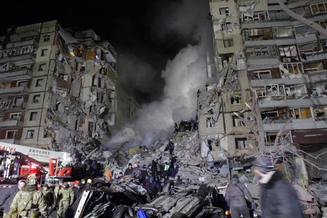 Los equipos de rescate buscan supervivientes entre los escombros de los edificios destruidos tras un ataque ruso con cohetes contra un bloque de apartamentos en Dnipro, Ucrania