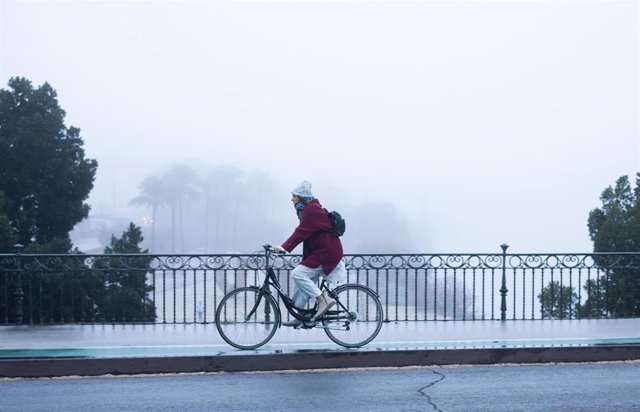 Una ciclista se protege del frío con gorro y guantes 