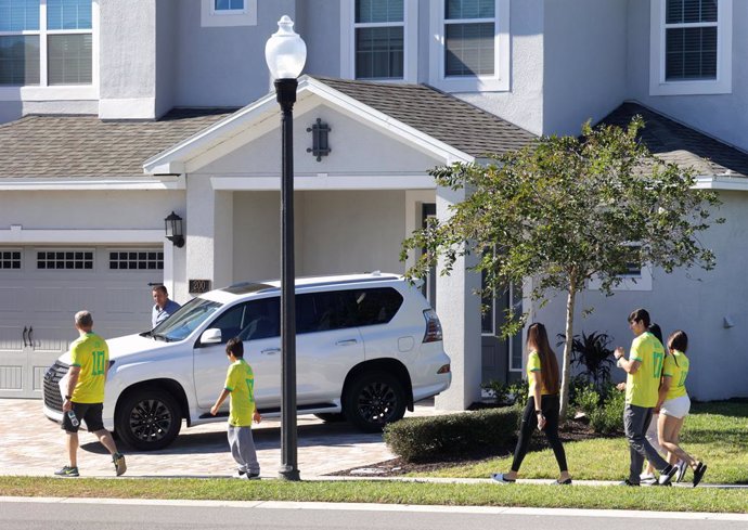 Simpatitzants de l'expresident del Brasil Jair Bolsonaro amb samarretes de la selecció brasilera de futbol caminen davant de la casa on l'exmandatari s'allotja durant la seva visita a Florida