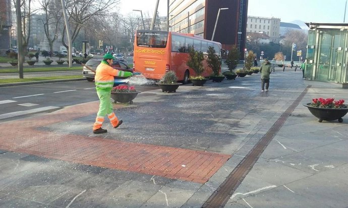 Imagen de un operario esparciendo sal en Bilbao.