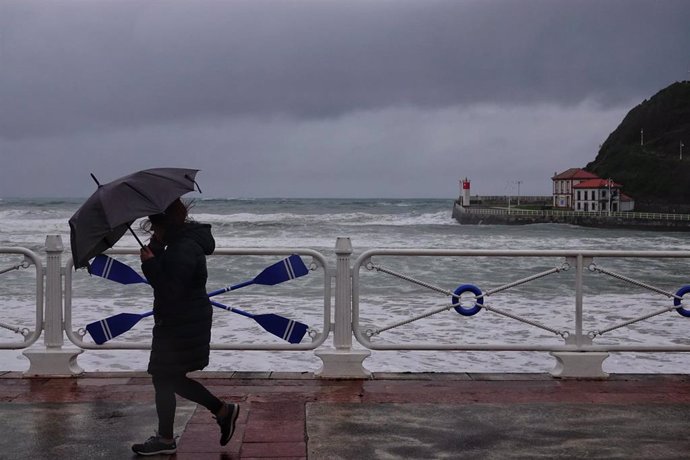 Una persona camina por el puerto de Ribadesella, a 16 de enero de 2023, en Ribadesella, Asturias (España). Asturias se encuentra hoy en aviso naranja por oleaje de hasta ocho metros de altura y en aviso amarillo por lluvias que podrían dejar hasta 50 li