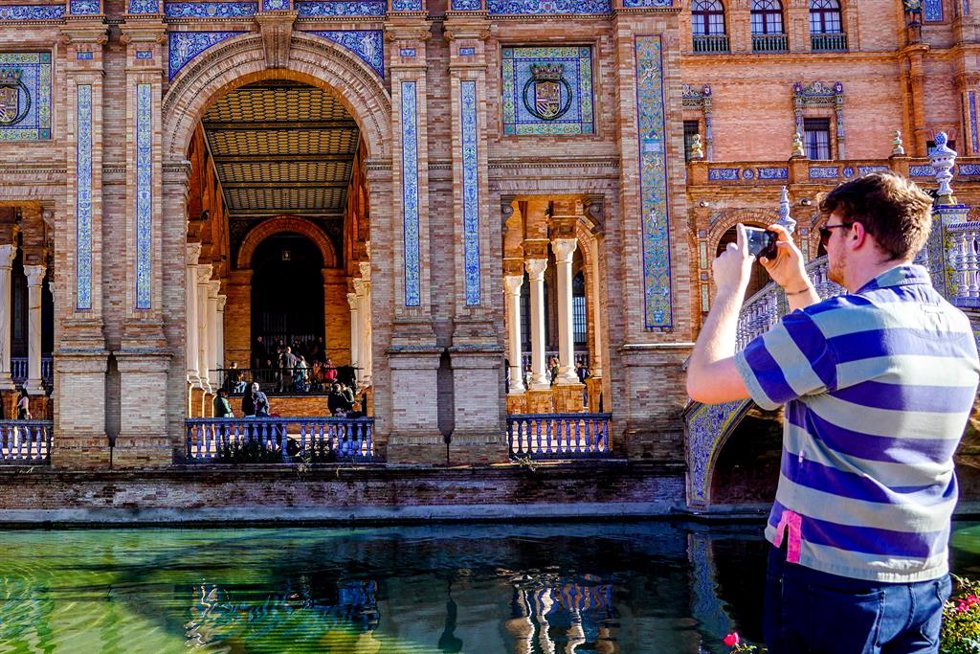 Turistas paseando y admirando la Plaza de España de Sevilla.