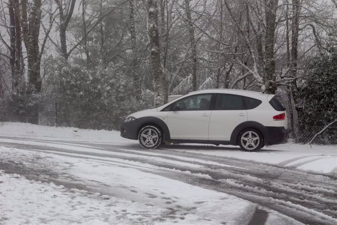 Un coche circula sobre la nieve en la parroquia de O Cebreiro, a 15 de enero de 2023, en Pedrafita do Cebreiro, Lugo, Galicia, (España). La llegada de una masa de aire polar ha traído un descenso térmico acompañado de lluvia y nieve a partir de hoy en b