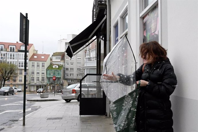 Una mujer abre un paraguas tras el paso de la borrasca Gérard, a 16 de enero de 2023, en A Coruña, Galicia (España). La borrasca Gérard, séptima de la temporada, se adelanta a la borrasca Fien y ha afectado hoy a España con viento, oleaje, nevadas y llu