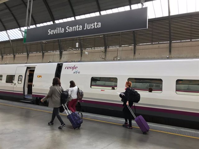 Pasajeros en la estación ferroviaria de Santa Justa, con el panel de horarios de los trenes al fondo.