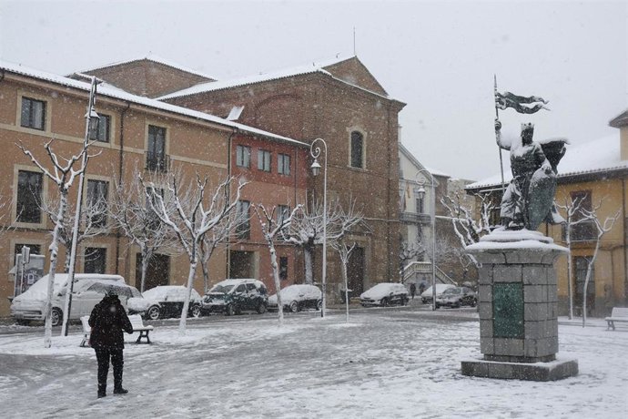 Una persona pasea por la calle mientras nieva en León, España.