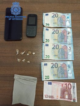 Dinero y papelinas interceptadas por los agentes tras la detención.