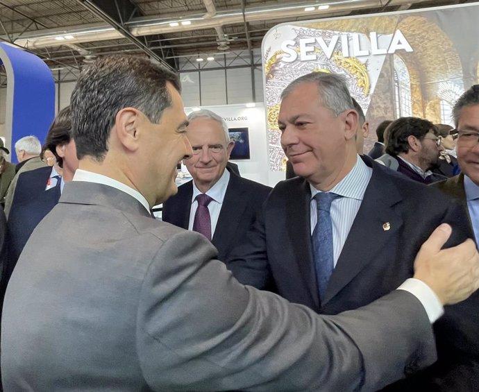 El presidente de la Junta, Juanma Moreno, saluda a José Luis Sanz, candidato del PP a la Alcaldía de Sevilla en Fitur, en Madrid.