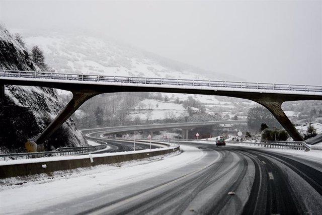 Un coche conduce por una carretera con nieve en Cantabria