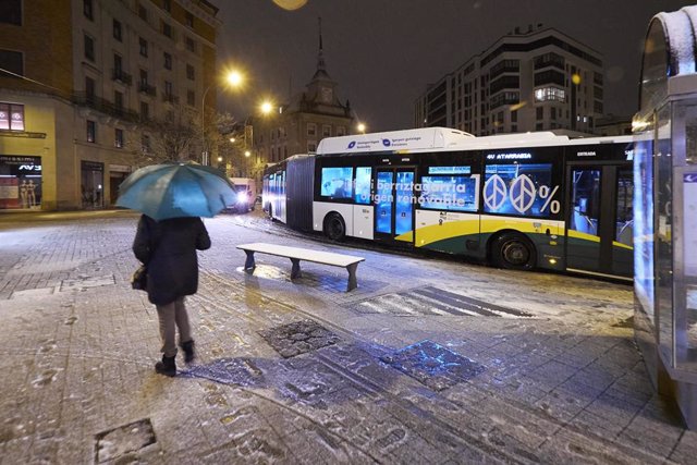 Una persona sujeta un paraguas mientras espera a un autobús, a 18 de enero de 2023, en Pamplona, Navarra (España). El fuerte temporal asociado a las borrascas Gérard y Fien ha hecho que Navarra amanezca hoy con abundantes precipitaciones de nieve en la zo
