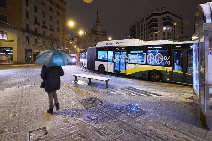Una persona sujeta un paraguas mientras espera a un autobús, a 18 de enero de 2023, en Pamplona, Navarra (España). El fuerte temporal asociado a las borrascas Gérard y Fien ha hecho que Navarra amanezca hoy con abundantes precipitaciones de nieve en la 