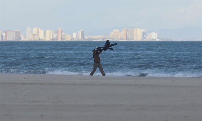 Una persona sujeta su chaqueta que está siendo arrastrada por el viento