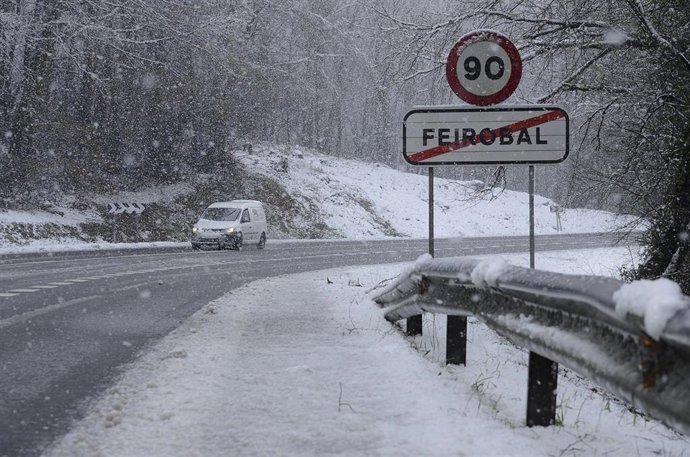 Un coche pasa por una carretera cubierta de nieve, a 18 de enero de 2023, en Ourense, Galicia (España). 