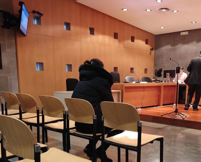 La acusada de un delito de abandono familiar sentada en el banquillo del Penal 1 de Oviedo.