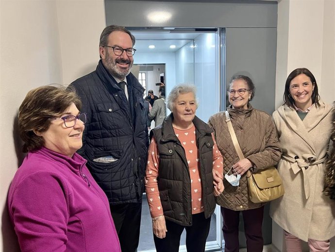 Adolfo Molina y Cristina Casanueva (dcha.), con vecinas del bloque donde se ha instalado el ascensor, ante el que posan.