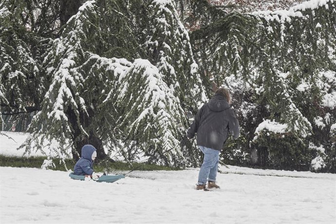 Una mujer lleva por la nieve a un niño en trineo, a 19 de enero de 2023, en Pamplona, Navarra (España). La Agencia Estatal de Meteorología (Aemet) mantiene la alerta naranja por acumulación de nieve en Navarra. Pamplona ha amanecido cubierta por una cap