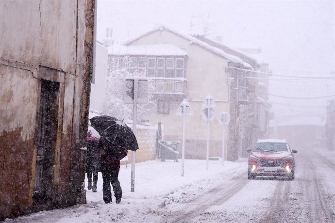 Una persona camina por una calle cubierta de nieve