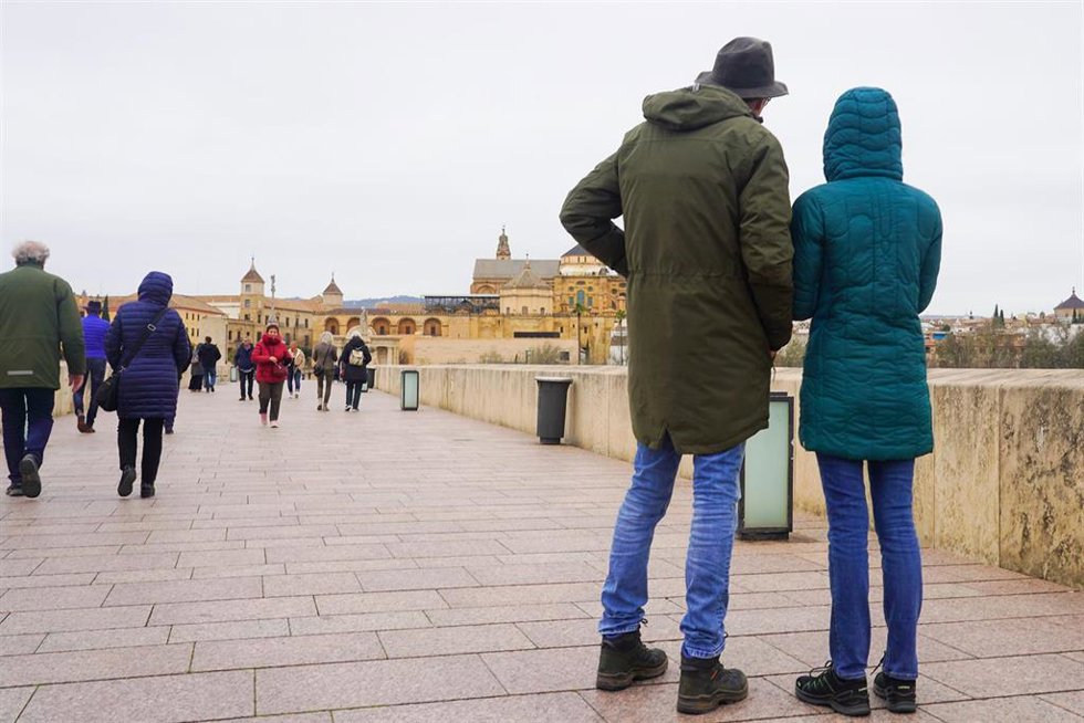 Transeúntes y turistas por el famoso puente de San Rafael con vistas a la Mezquita .