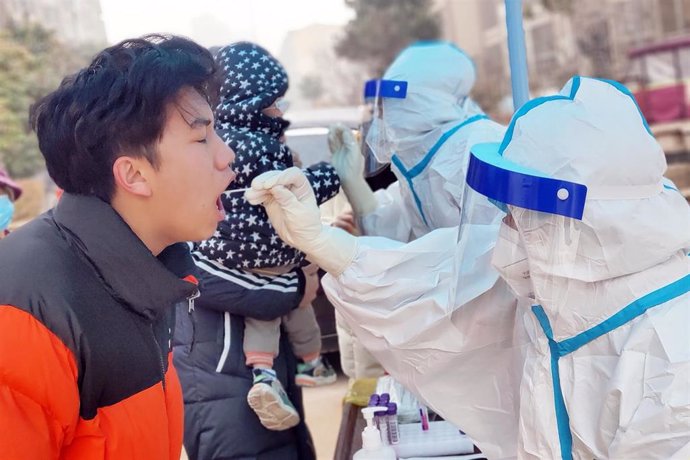 Archivo - 10 January 2022, China, Anyang: Health workers take swabs for the Covid-19 test from residents of Huatong Century City Community in the sealed area of Hua county, Anyang City. China records 157 new confirmed cases of the corona, 97 of which ar