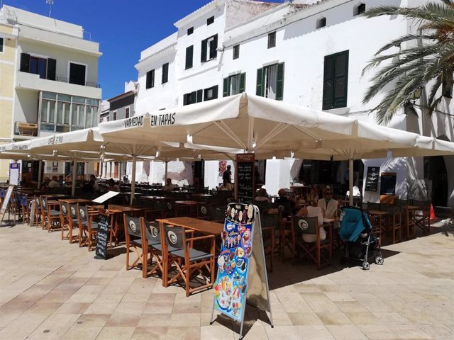 Archivo - Una terraza de un café-restaurante de Ciutadella un día soleado, con sombrillas.