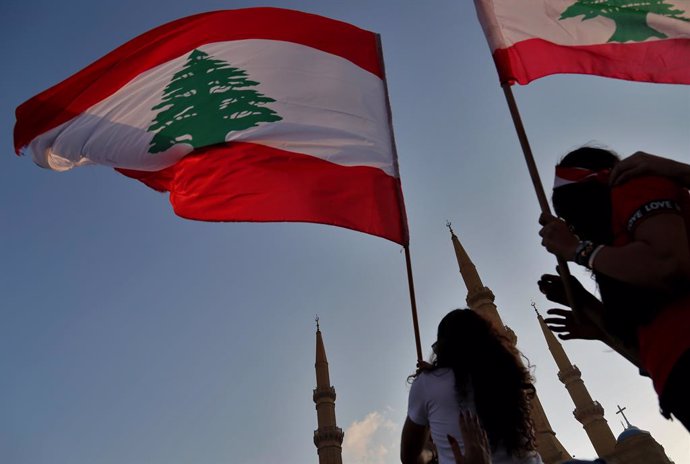 Archivo - 20 October 2019, Lebanon, Beirut: Lebanese demonstrators wave their country's flag during a protest. For the fourth Lebanese are still taking the streets across country demanding the fall of the government and the regime. Photo: Marwan Naamani