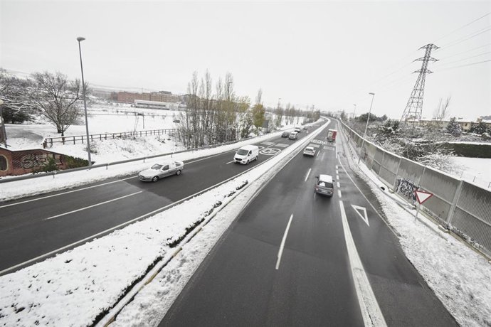 Varios coches circulan por una carretera con los laterales cubiertos de nieve, a 19 de enero de 2023, en Pamplona, Navarra (España). La Agencia Estatal de Meteorología (Aemet) mantiene la alerta naranja por acumulación de nieve en Navarra. Pamplona ha a