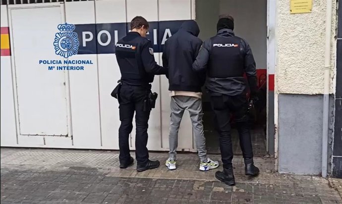Agentes de la Policía Nacional con uno de los detenidos por una riña tumultuaria con lanzamientos de sillas y armas blancas en Palma