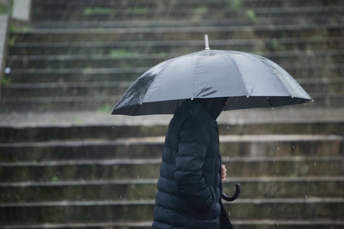 Una persona con paraguas para protegerse de la lluvia camina por la Rua Loureiro Crespo, a 16 de enero de 2023, en Pontevedra, Galicia (España).   