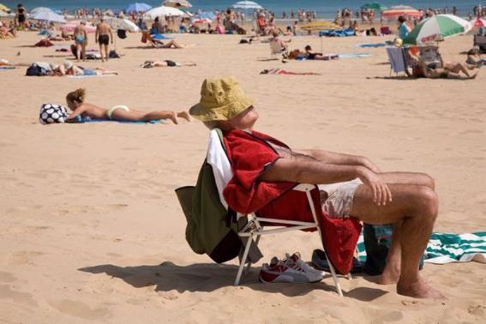 Un hombre toma el sol en una playa.