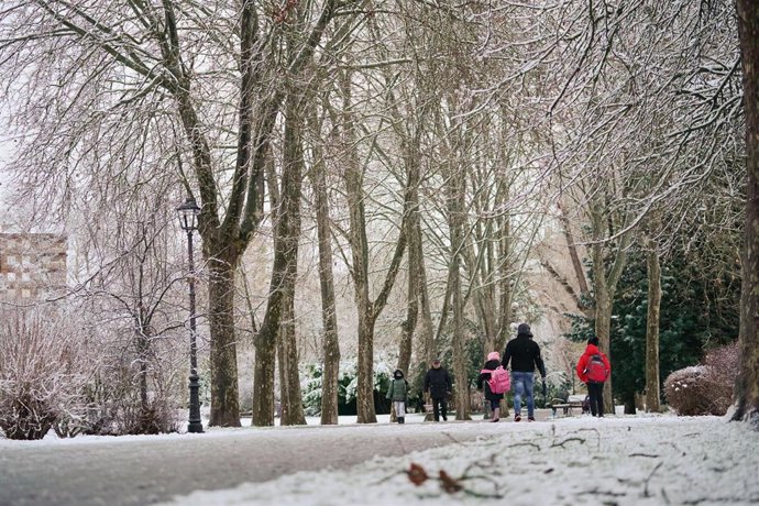 Varias personas pasean por un parque cubierto de nieve, a 18 de enero de 2023, en Vitoria-Gasteiz 