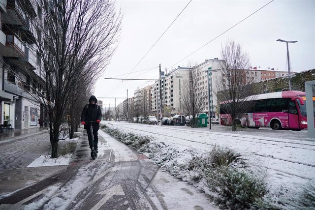 Un hombre camina por una calle con hielo y niev en Vitoria-Gasteiz, Álava