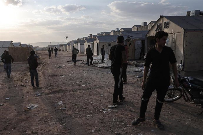 Archivo - Un grupo de personas inspecciona los daños tras un ataque contra un campamento de desplazados en la provincia de Idlib, en el noroeste de Siria