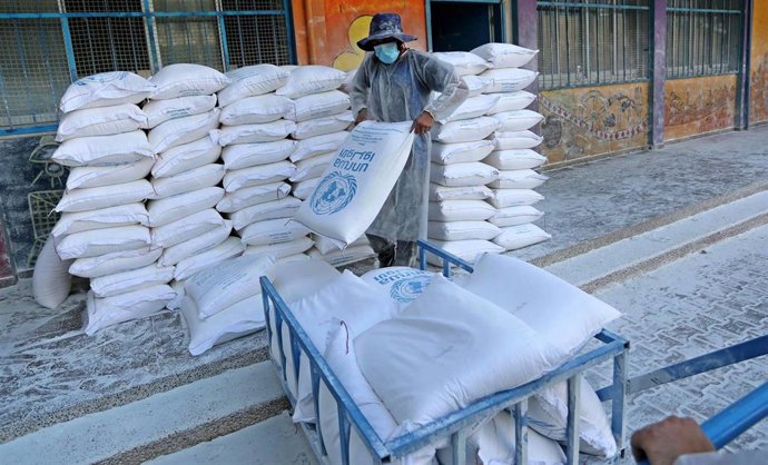 Archivo - Un empleado de la Agencia de Naciones Unidas para los Refugiados de Palestina en Oriente Próximo (UNRWA) durante un reparto de ayuda en Jan Yunis, en la Franja de Gaza