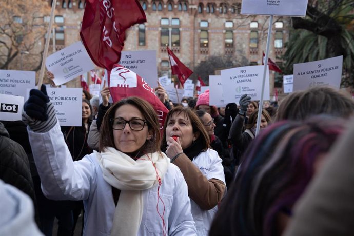Varias personas protestan con pancartas y batas blancas durante una manifestación del sindicato médico Médicos de Cataluña por la huelga sanitaria, a 25 de enero de 2023, en Barcelona, Cataluña (España). La huelga sanitaria se mantiene hoy y mañana, jue