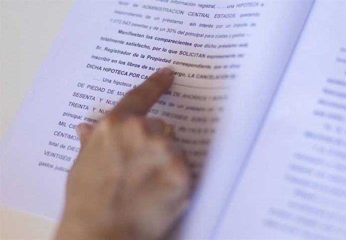 Archivo - Una mujer señala una escritura de compraventa de una hipoteca, a 30 de mayo de 2022, en Madrid (España). Los portales inmobiliarios han destacado el crecimiento del 18% en la firma de hipotecas sobre viviendas hasta su mayor cifra en 11 años (
