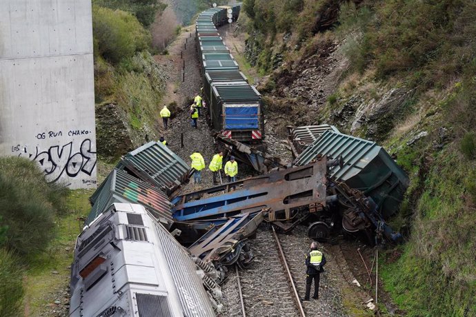 Varios hombres realizan las labores de retirada del tren accidentado, a 24 de enero de 2023, en A Xesta, Lalín, Pontevedra (España). 