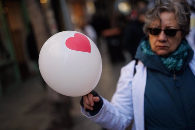 Una mujer con un globo con un corazón participa en una manifestación por la Atención Primaria