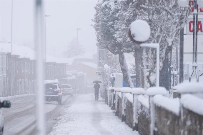 Una persona camina por una calle cubierta de nieve en Cantabria (España).- Archivo