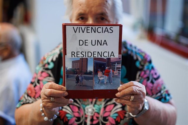 Archivo - Una mujer posa con un diario sobre sus vivencias de la pandemia en una residencia de mayores.