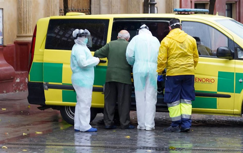 Archivo - Profesionales protegidos acompañan a un mayor de una residencia a una ambulancia durante la pandemia.