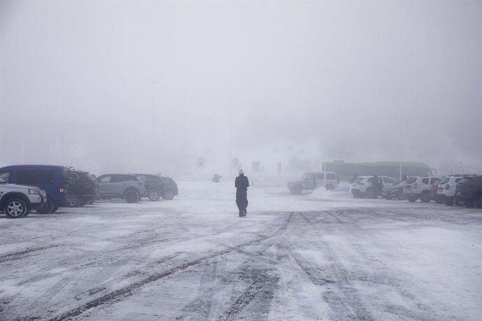 Una persona camina por la nieve en el parking del Puerto de Navacerrada, a 19 de enero de 2023, en Navacerrada, Madrid (España). La Agencia de Seguridad y Emergencias de la Comunidad de Madrid (ASEM 112) ha activado la situación 0 de la fase de alerta d
