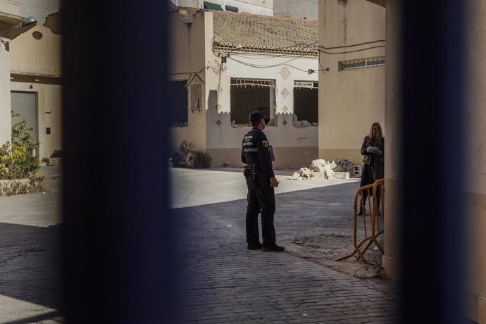 Un agente de policía conversa con la propietaria de las naves de Zaidía