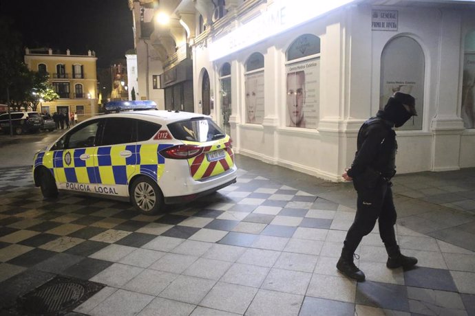 Un policía local corta una calle aledaña a la plaza donde estaba el cadáver del sacristán asesinado en Algeciras